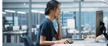 In Big Diverse Corporate Office: Portrait of Beautiful Asian Manager Using Desktop Computer, Businesswoman Managing Company Operations, Analysing Statistics, Commerce Data, Marketing Plans.