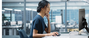In Big Diverse Corporate Office: Portrait of Beautiful Asian Manager Using Desktop Computer, Businesswoman Managing Company Operations, Analysing Statistics, Commerce Data, Marketing Plans.